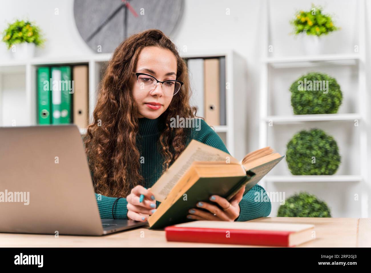 Ein Mädchen mit mittlerer Schussweite, das mit Wörterbuch lernt Stockfoto