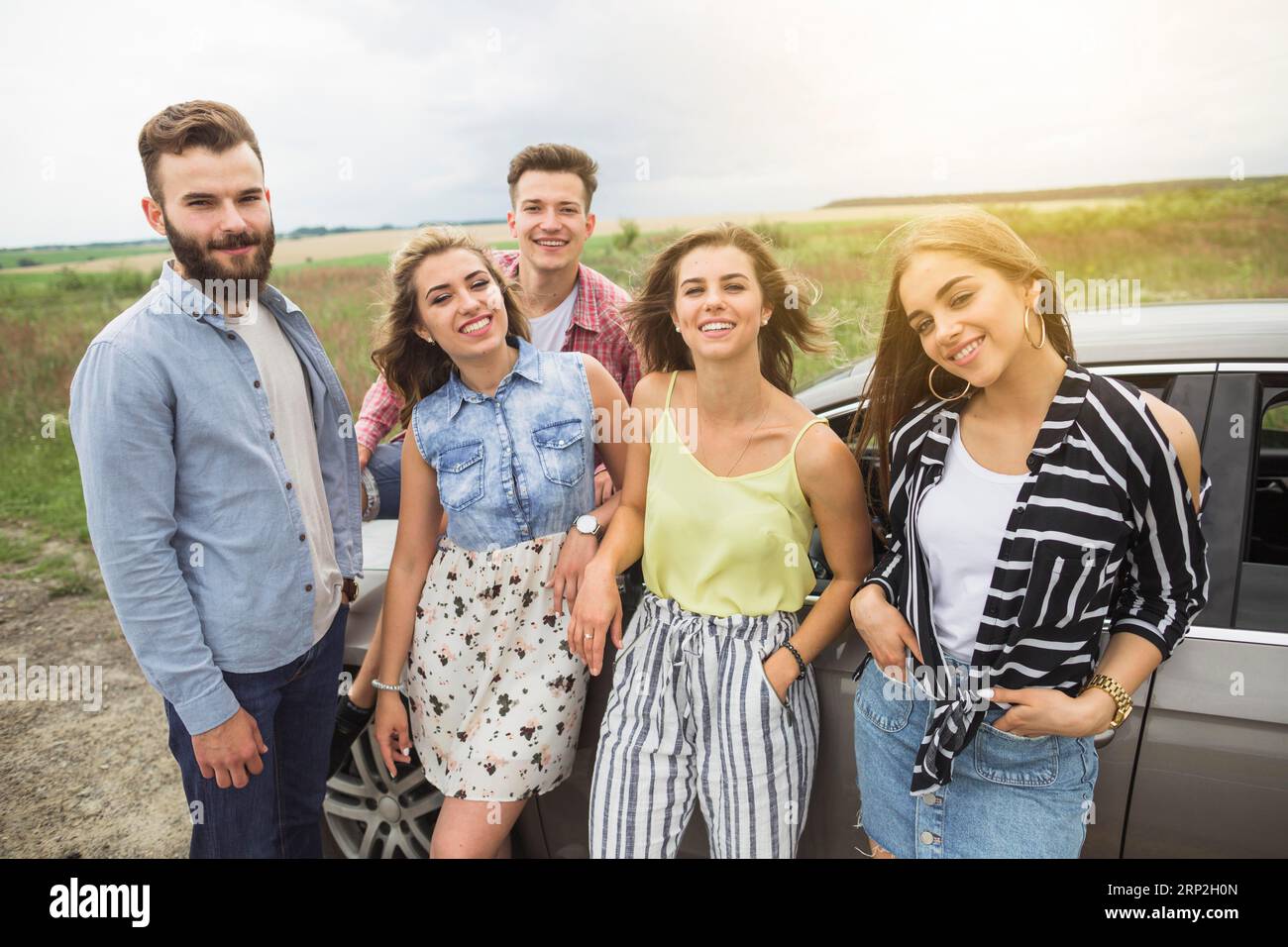 Portrait glückliche Freunde stehen Feld in der Nähe des Autos Stockfoto