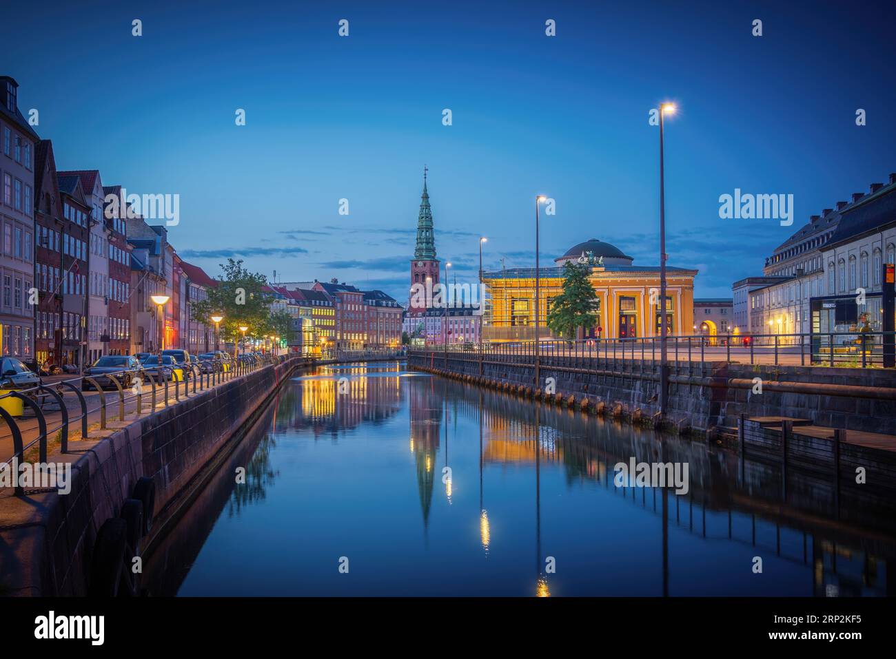 Skyline des Kopenhagener Kanals und Slotsholmen mit Nikolaj Kunsthal-Turm bei Nacht - Kopenhagen, Dänemark Stockfoto