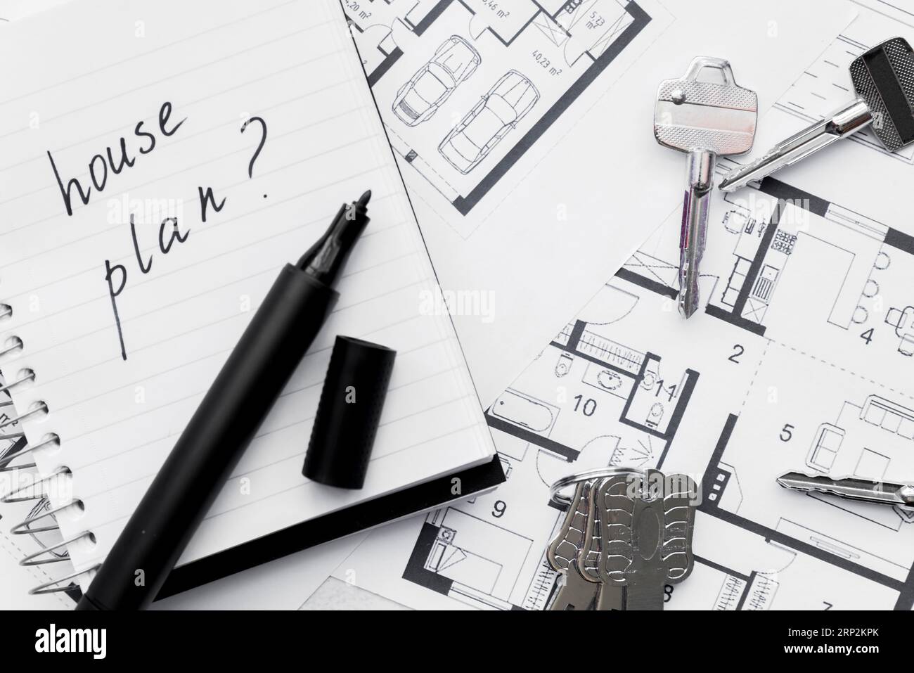 Hausplan mit Fragezeichen geschriebenes Notizbuch mit Filzstift-Tasten und blauem Druck Stockfoto