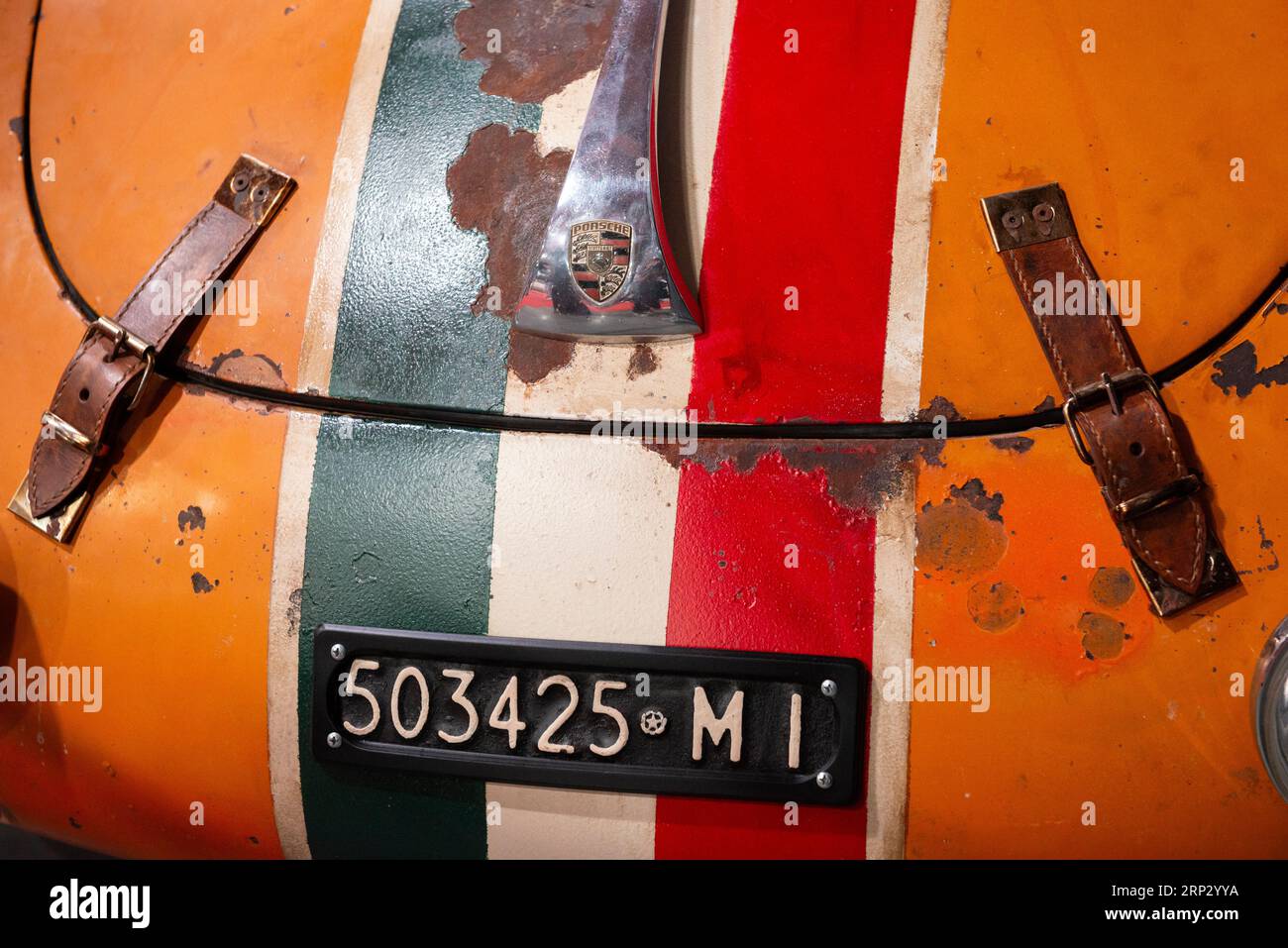 Vorderansicht des orangefarbenen Porsche 356 C 1600 Rennwagens von 1964 mit italienischem Kennzeichen, italienischer Flaggenaufkleber und Lederhaube oder Motorhaubenriemen Stockfoto