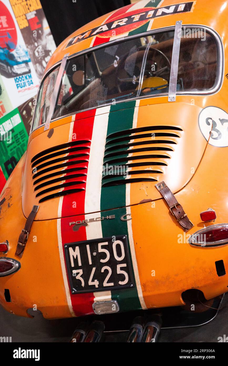 Rückansicht des orangefarbenen Porsche 356 C 1600 Rennwagens von 1964 mit italienischem Kennzeichen, Martini-Schriftzug und italienischer Flagge Stockfoto