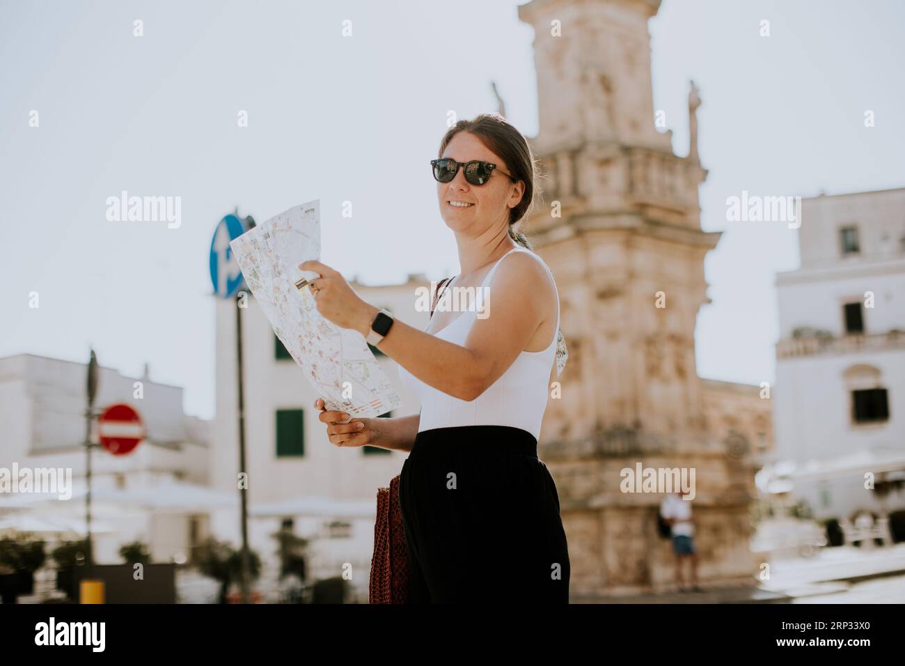 Weibliche Touristen mit einem Stadtplan von der Statue des Heiligen Oronzo in Ostuni, Italien Stockfoto
