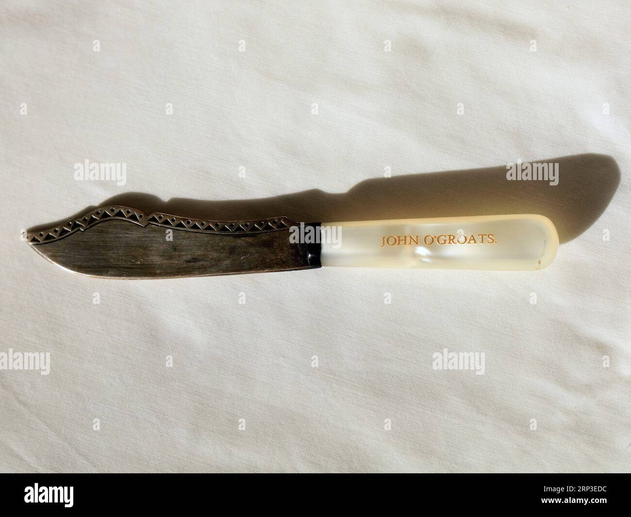 Kleines dekoratives Souvenir-Messer mit Perlenstiel - mit der Markierung John O'Groats. Weißer Hintergrund Stockfoto