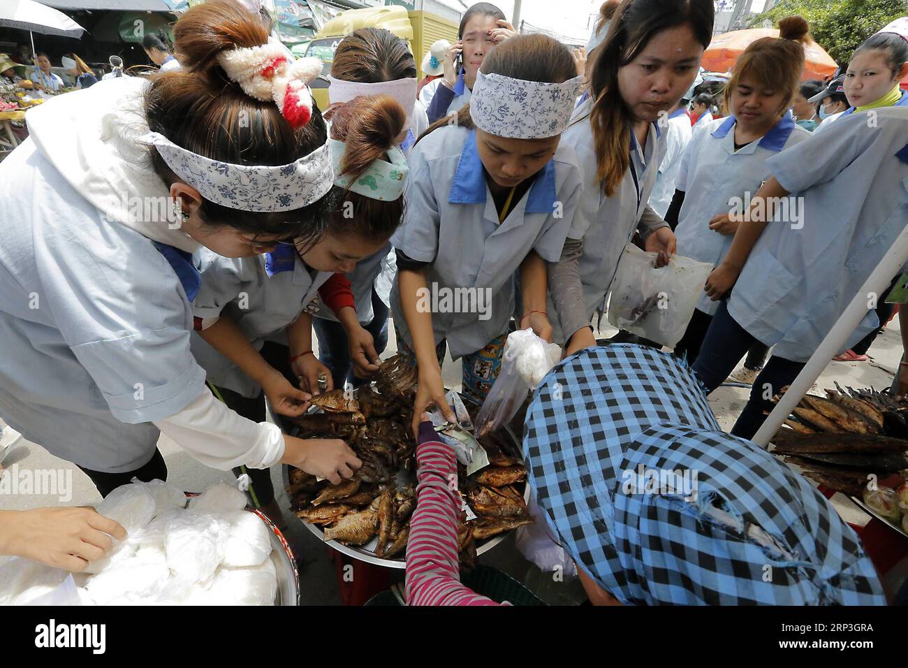 (181005) -- PHNOM PENH, 5. Oktober 2018 -- Kambodschanische Bekleidungsarbeiter kaufen am 5. Oktober 2018 in Phnom Penh, Kambodscha, Street Food zum Mittagessen. Die kambodschanische Regierung setzte am Freitag einen neuen monatlichen Mindestlohn für die Multi-Milliarden-Dollar-Bekleidungs- und Schuhindustrie des Landes auf 182 US-Dollar für 2019 fest, was 7 Prozent mehr als die aktuellen 170 US-Dollar ist, teilte Arbeitsminister Ith Samheng mit. ) KAMBODSCHA-PHNOM PENH-MINDESTLOHN-BEKLEIDUNG-SCHUHE-ERHÖHEN PHEARUM PUBLICATIONXNOTXINXCHN Stockfoto