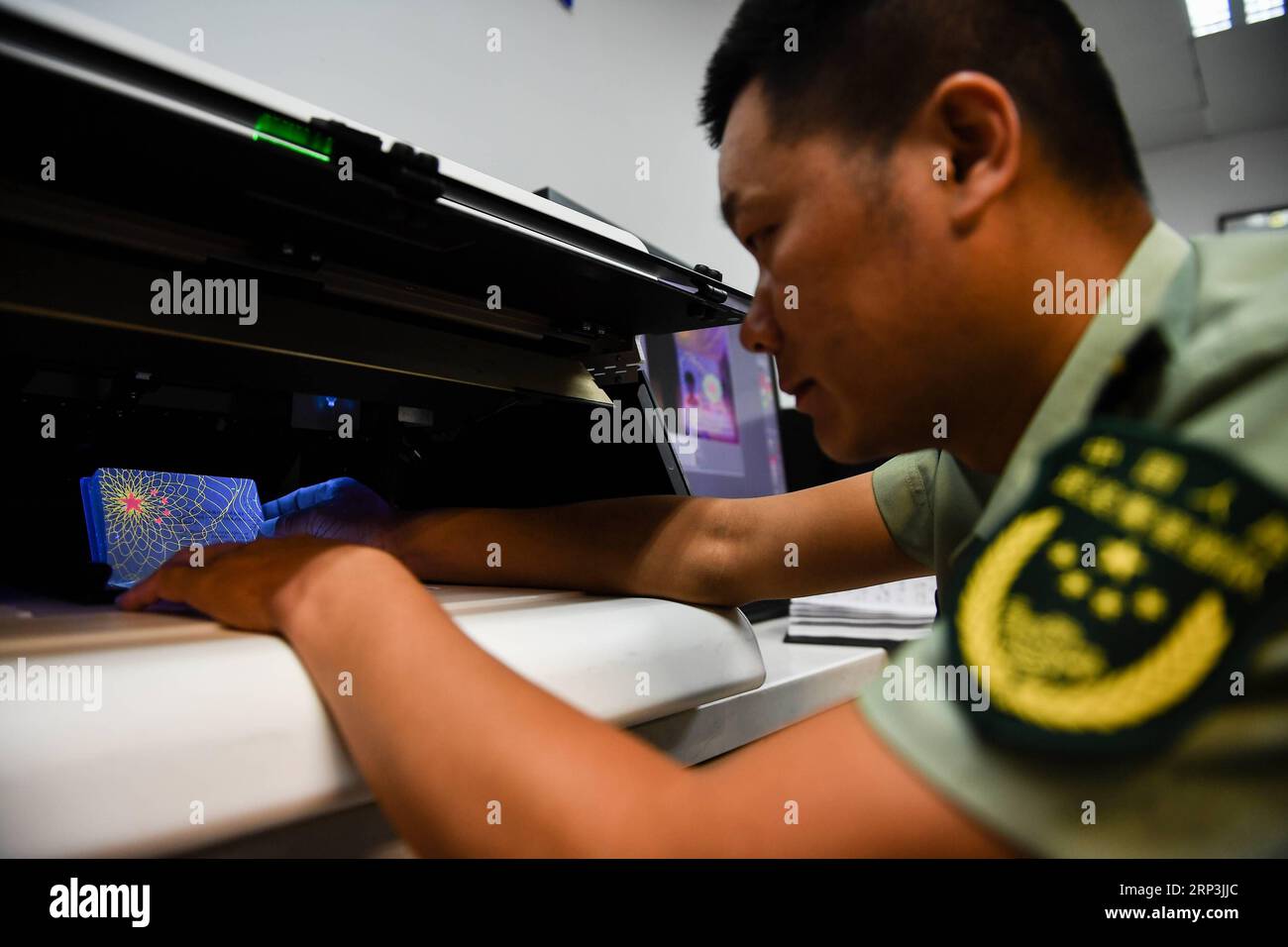 (181008) -- NANJING, 8. Oktober 2018 -- Wang Zhiguo arbeitet an einer Inspektionsstation des Nanjing Lukou International Airport in Nanjing, Hauptstadt der ostchinesischen Provinz Jiangsu, 7. August 2018. Wang Jicai, der früher Leiter des Milizpostens auf Kaishan Island in der Provinz Jiangsu war, begann 1986 mit seiner Frau auf der Insel im Gelben Meer zu arbeiten. Im Juli 2018 starb er im Alter von 58 Jahren an plötzlichen Krankheiten. Wang Zhiguo, Sohn von Wang Jicai, wurde nach seinem Abschluss an der Nanjing University of Aeronautics and Astronautics 2013 Grenzschutzpolizist. Er war zugeteilt worden Stockfoto