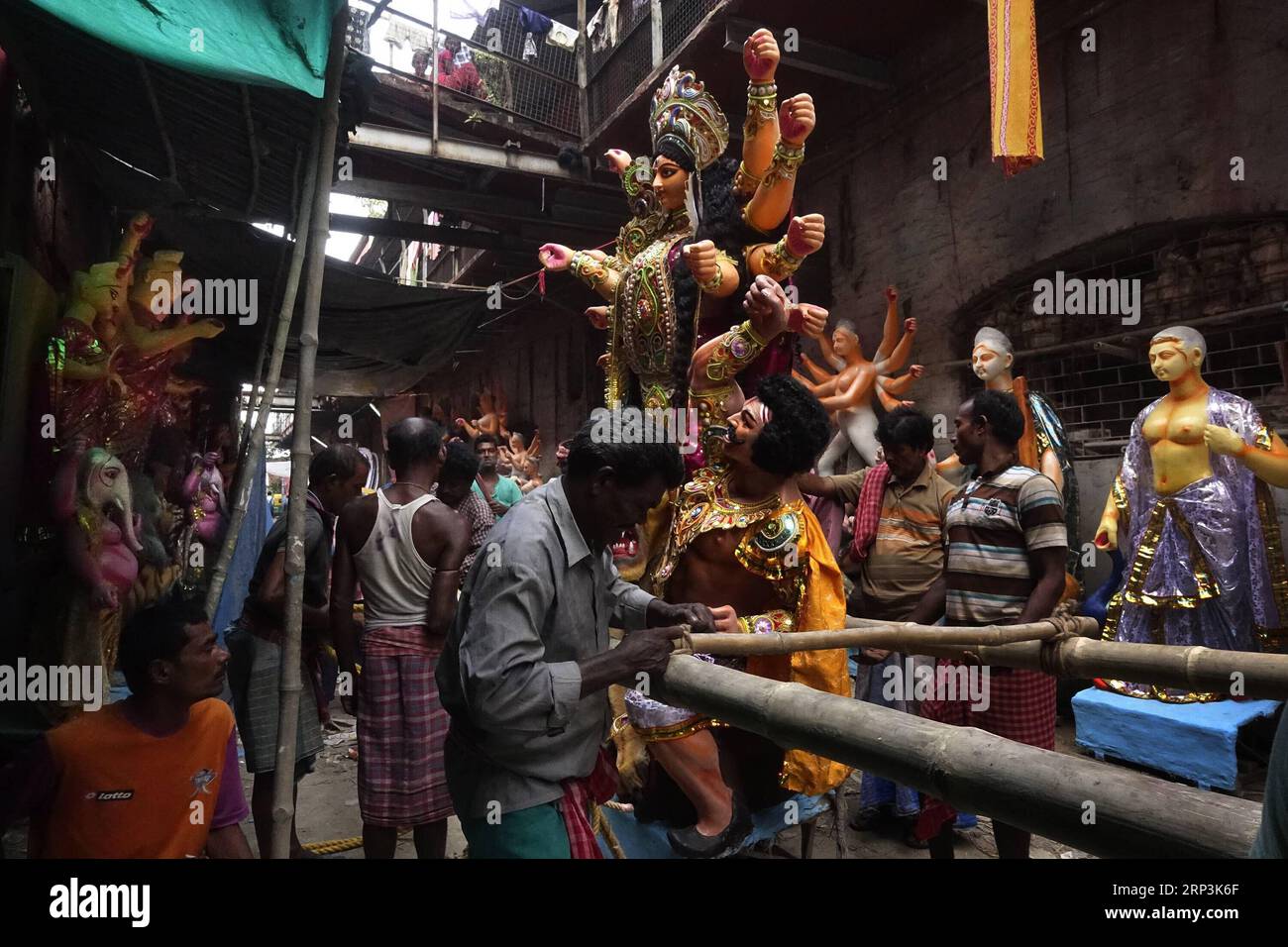 (181009) -- KOLKATA, 9. Oktober 2018 -- die Arbeit bereitet sich darauf vor, ein Tonidol der Göttin Durga für das bevorstehende Durga-Puja-Festival am 9. Oktober 2018 in Kolkata, Indien, zu tragen. Durga Puja ist eines der größten hinduistischen Festivals, bei dem die Göttin Durga verehrt wird, die in der hinduistischen Mythologie die Macht und den Triumph des Guten über das Böse symbolisiert. (dtf) INDIEN-KOLKATA-DURGA-TON IDOL HERSTELLUNG TumpaxMondal PUBLICATIONxNOTxINxCHN Stockfoto