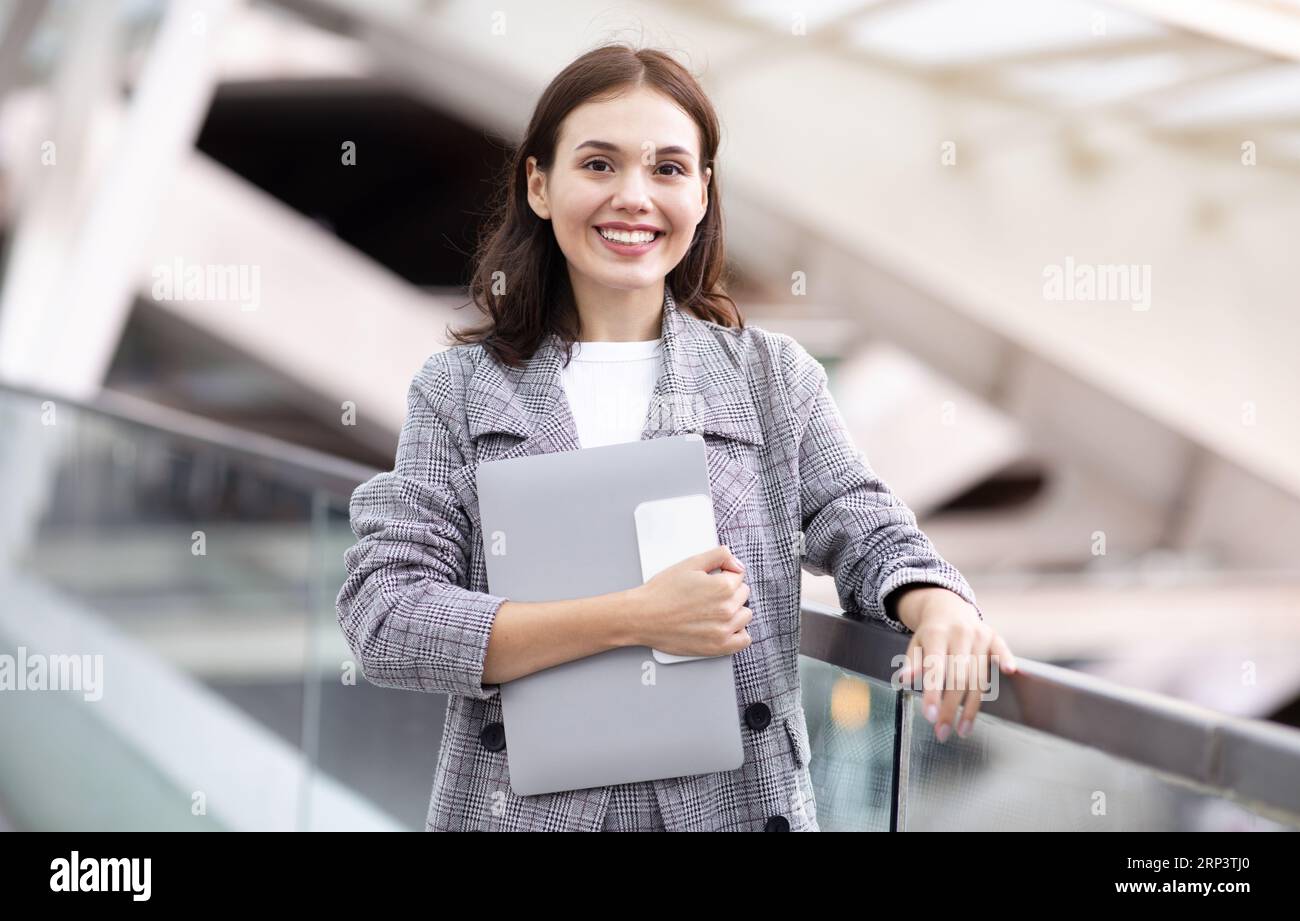 Happy Young Business Woman Holding Laptop And Smartphone At Modern Airport Stockfoto