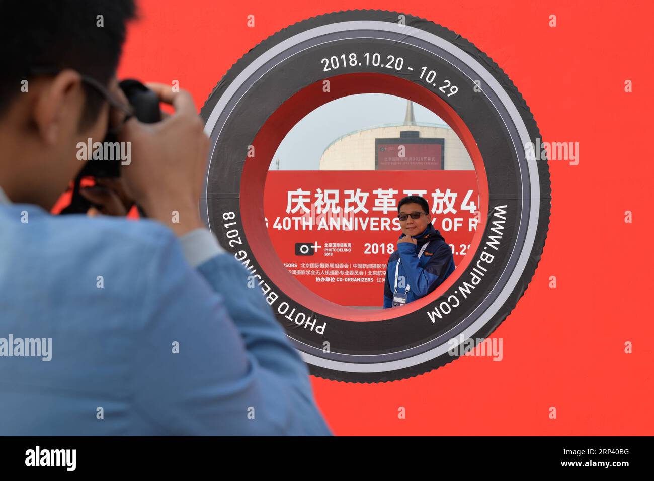 (181020) -- PEKING, 20. Oktober 2018 (Xinhua) -- Ein Gast posiert für Fotos bei der Eröffnungszeremonie von Foto Peking 2018 am China Millennium Monument in Peking, Hauptstadt von China, 20. Oktober 2018. Photo Beijing 2018, eine internationale Fotoveranstaltung, wurde hier am Samstag eröffnet. Vom 20. Bis 29. Oktober findet eine Reihe von Ausstellungen, Vorträgen, Märkten und besonderen Aktivitäten statt. (Xinhua/Xu Qin)(lmm) CHINA-BEIJING-ART-PHOTOGRAPHY-EVENT (CN) PUBLICATIONxNOTxINxCHN Stockfoto