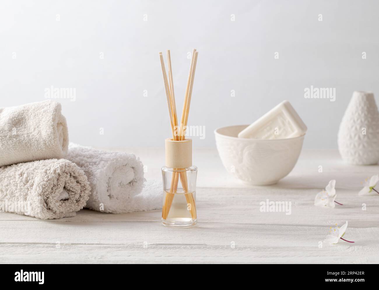 Badezimmer. Weiche Handtücher, eine Tasse Seife und eine Vase mit Duftstäbchen. Minimalistischer Stil, hochwertiges Foto Stockfoto