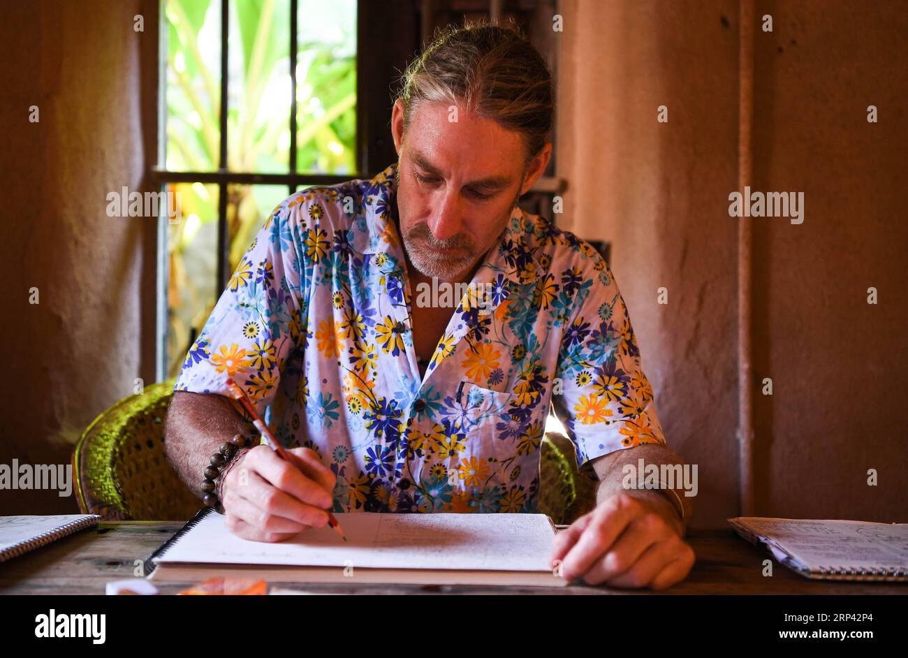 (181023) -- HAIKOU, 23. Oktober 2018 -- der Kanadier Craig Anderson arbeitet auf der Westinsel in Sanya, Südchinesische Provinz Hainan, 20. September 2018. Anderson kam im Februar auf der West Island an, wo etwa 4.000 Menschen lebten. Die Einheimischen betrachteten Anderson als einen Schnitzer, als er zum ersten Mal ankam, als er fast jeden Tag am Strand umherwanderte und Treibholz, Plastikflaschen, zerbrochene Gläser und rostige Eisenstücke aufnahm. Im Laufe der Zeit erkannten die Einheimischen, dass Anderson ein Künstler ist, der sich dem Umweltschutz widmet. Er profitiert von den recycelbaren und regenerativen Materialien Stockfoto