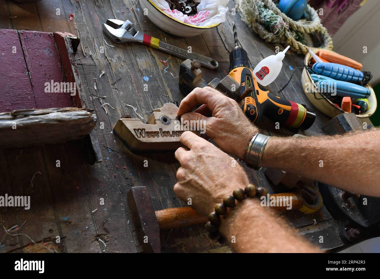(181023) -- HAIKOU, 23. Oktober 2018 -- der Kanadier Craig Anderson arbeitet im Öko-Nachhaltigkeits-Servicezentrum der Westinsel in Sanya, Südchinesische Provinz Hainan, 19. September 2018. Anderson kam im Februar auf der West Island an, wo etwa 4.000 Menschen lebten. Die Einheimischen betrachteten Anderson als einen Schnitzer, als er zum ersten Mal ankam, als er fast jeden Tag am Strand umherwanderte und Treibholz, Plastikflaschen, zerbrochene Gläser und rostige Eisenstücke aufnahm. Im Laufe der Zeit erkannten die Einheimischen, dass Anderson ein Künstler ist, der sich dem Umweltschutz widmet. Er profitiert von Stockfoto