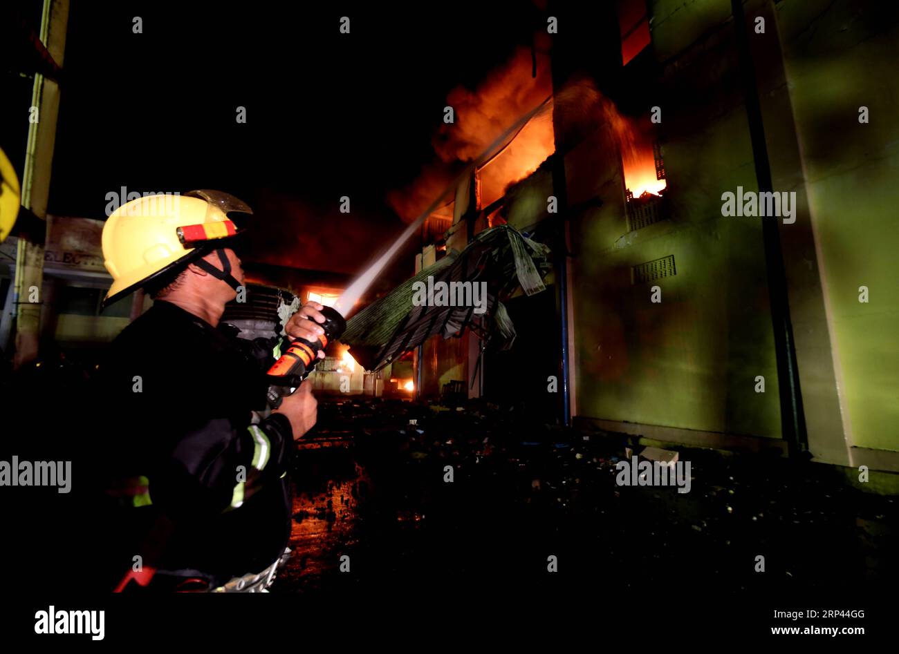 (181026) -- , Oktober 26, 2018 -- Ein Feuerwehrmann versucht, Ein Feuer in Hlaingthaya Township of Myanmar s, Oktober 26, 2018 zu löschen. Am späten Donnerstag brach in der Fabrik von AA Electronics in der Stadt Hlaingthaya in Myanmar ein riesiges Feuer aus. U Aung) (yk) MYANMAR--FIRE yangon PUBLICATIONxNOTxINxCHN Stockfoto