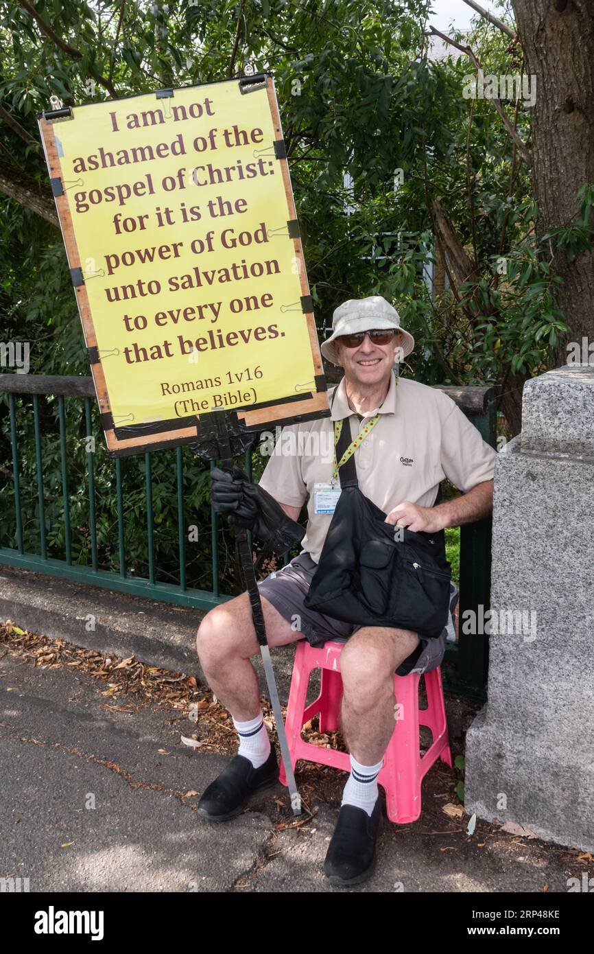 Mann mit einem Plakat mit christlicher Botschaft, evangelistisches Kirchenmitglied, das seinen religiösen Glauben an Menschen auf der Straße, England, Großbritannien, kommuniziert Stockfoto