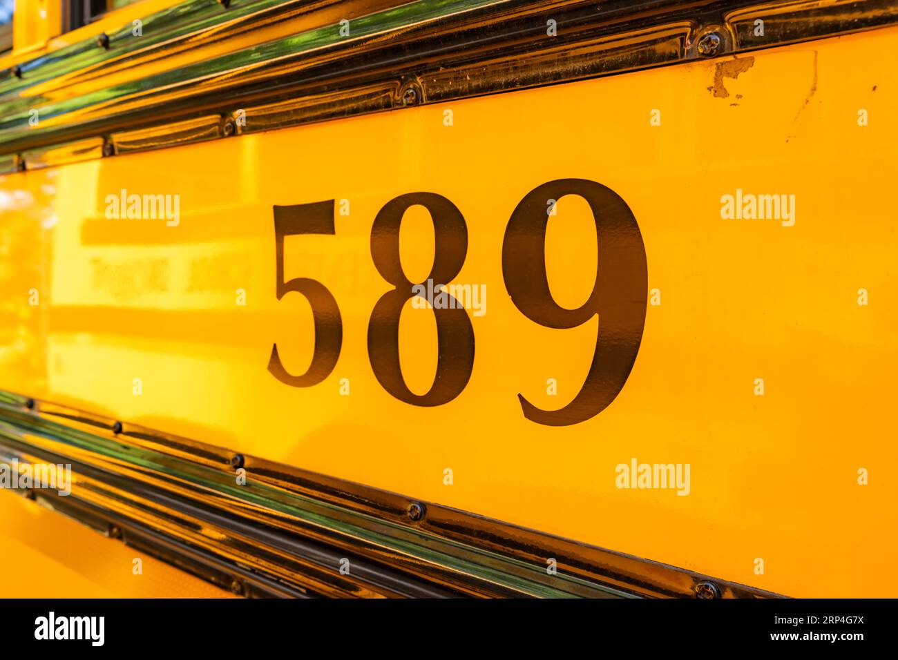 Seite eines geparkten gelben Schulbusses Nummer 589 Stockfoto