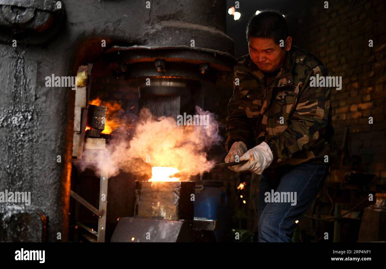 (181114) -- SHIJIAZHUANG, 14. November 2018 -- Li Zhujun stellt ein dekoratives Schwert in seinem Atelier im Dorf Tiejiangzhuang im Kreis Xingtang, Shijiazhuang, nordchinesische Provinz Hebei, 14. November 2018 her. Seit Jahrhunderten ist das Dorf Tiejiangzhuang berühmt für seine geschickten Schmiede und die wohlhabende Stahlindustrie. Li Zhujun ist einer der besten Stahlhersteller des Dorfes. Auf der Grundlage der von seinem Vater geerbten Fähigkeiten erlangte Li ein Know-how in der Stahlherstellungstechnik für verfeinertes Musterschweißen, das den Schwertern und Messern beim Schmieden komplizierte Muster hinzufügt. Die Technik wurde als aufgeführt Stockfoto
