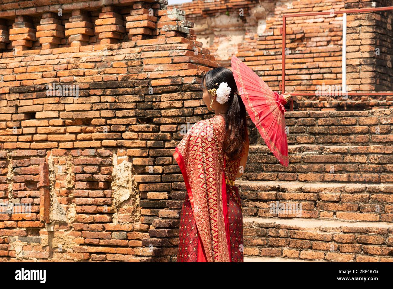 asiatische Frau in traditionellem thailändischem Anzug mit Schirm vor dem alten Tempel im ayutthaya-Weltkulturerbe von unesco-thailand. Ayutthaya, Thailand M. Stockfoto