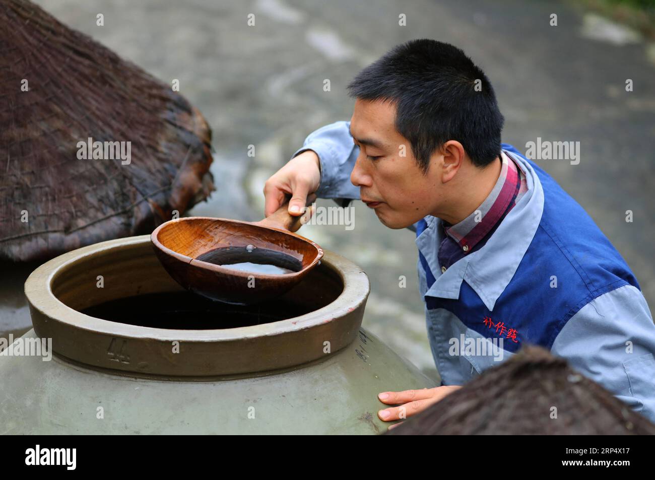 (181119) -- ZUNYI, 19. November 2018 -- Ein Arbeiter kontrolliert den Essig, der in einem Glas in einer Essigfabrik in Chishui, Provinz Guizhou im Südwesten Chinas, am 18. November 2018 ausgestoßen wurde. Chishui hat eine traditionelle Methode zur Essigherstellung mit über 30 Prozessschritten beibehalten.) (Ry) CHINA-GUIZHOU-ESSIGHERSTELLUNG (CN) WangxChangyu PUBLICATIONxNOTxINxCHN Stockfoto