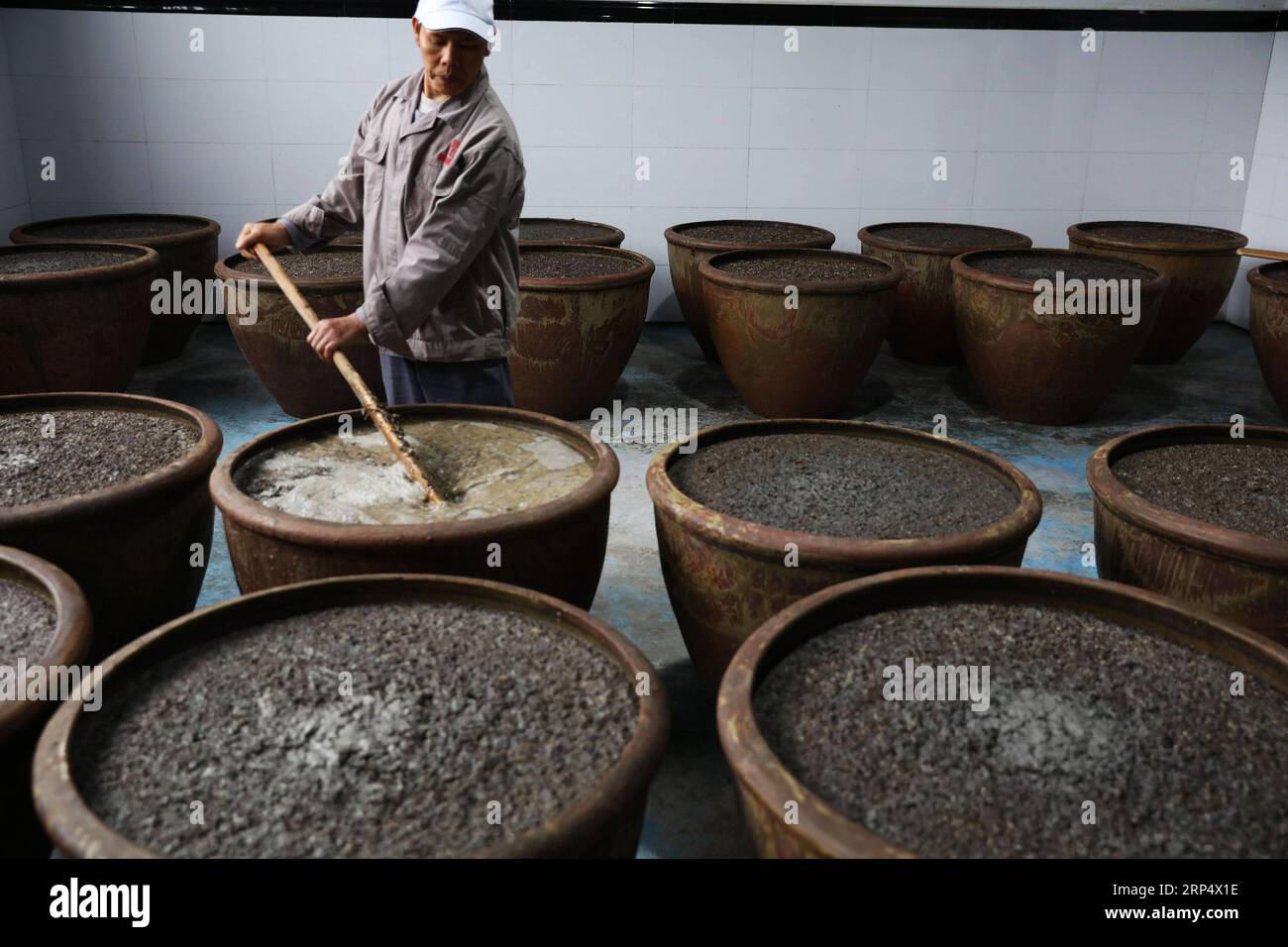 (181119) -- ZUNYI, 19. November 2018 -- Ein Arbeiter rührt Rohstoffe zur Essigherstellung in einer Essigfabrik in Chishui, südwestchinesische Provinz Guizhou, 18. November 2018. Chishui hat eine traditionelle Methode zur Essigherstellung mit über 30 Prozessschritten beibehalten.) (Ry) CHINA-GUIZHOU-ESSIGHERSTELLUNG (CN) WangxChangyu PUBLICATIONxNOTxINxCHN Stockfoto