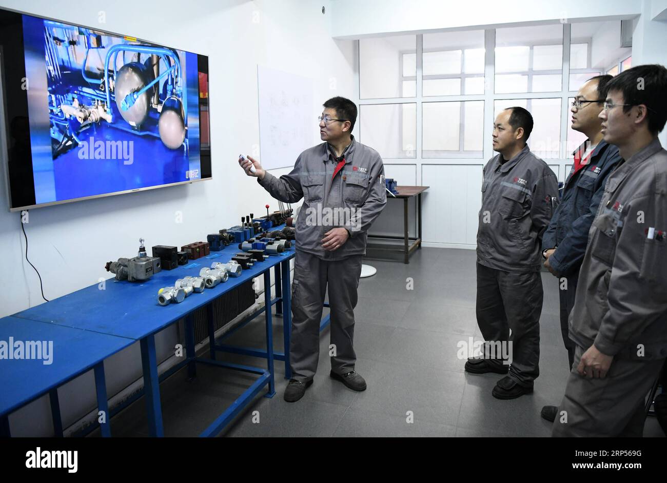 (181130) -- HARBIN, 30. November 2018 (Xinhua) -- Zhu Wentao (L) kommuniziert mit Kollegen in seinem Atelier in Qiqihar, nordöstliche Provinz Heilongjiang, 29. November 2018. Als leitender Techniker der China Railway Rolling Stock Corporation (CRRC) Qiqihar Co Ltd., Zhu hat mehrfach Preise für seine hervorragende berufliche Leistung erhalten. Als Meister der Werkzeuge ist er in der Lage, Stahlschrott so fein zu drehen, dass er weniger als ein Siebtel des Durchmessers gewöhnlicher menschlicher Haare beträgt. (Xinhua/Wang Jianwei) (gxn) CHINA-HEILONGJIANG-QIQIHAR-TECHNIKER (CN) PUBLICATIONxNOTxINxCHN Stockfoto