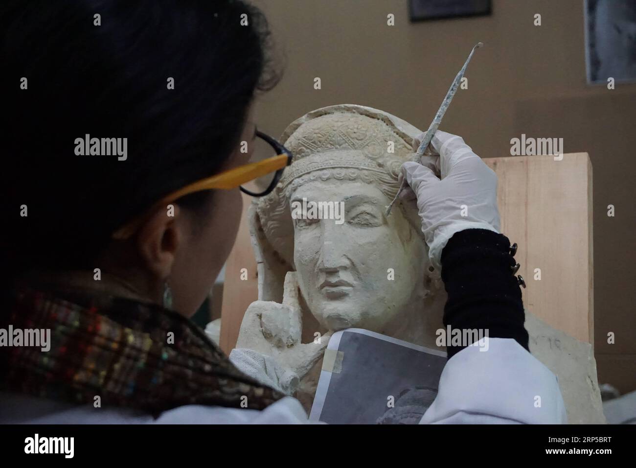 (181207) -- DAMASKUS, 7. Dezember 2018 -- Heba Jouma, eine Restauratorin und Restauratorin der antiken Stadt Palmyra in Syrien und Mitglied eines syrischen Experten-Teams für Restaurierung, arbeitet am 5. Dezember 2018 im Nationalen Museum von Damaskus in Damaskus, Syrien. Heba Jouma arbeitet daran, die antiken Merkmale der Skulpturen, die von der IS-Gruppe beschädigt wurden, zurückzubringen. Die IS-Gruppe hatte Palmyra während des mehr als siebenjährigen Krieges zweimal stürmt, kostbare archäologische Stätten wie Tempel und Gräber zerstört und Skulpturen in Stücke zerstückelt in der antiken Oasenstadt, die von der UNESCO A registriert ist Stockfoto