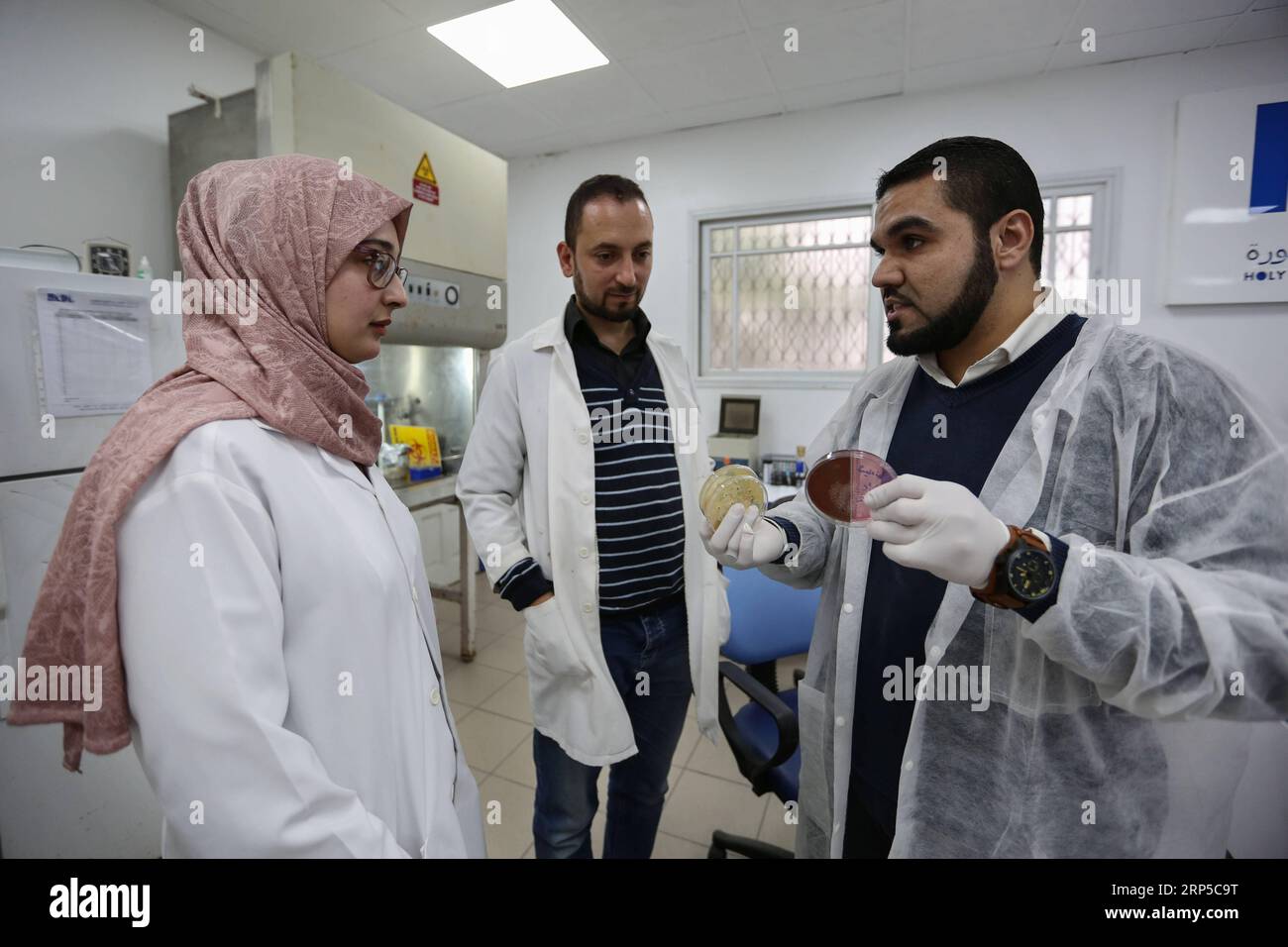(181208) -- GAZA, 8. Dezember 2018 -- palästinensische junge Wissenschaftler Salah al-Sadi (C), 36, Mahmoud al-Hindi (R), 29 und Reem Jabor (L), 22, arbeiten am 5. Dezember 2018 in einem Labor in Gaza-Stadt. Ein Team junger palästinensischer Wissenschaftler aus dem Gazastreifen versucht, Antibiotika und Pilze durch Nanotechnologie zu entwickeln. Das Team, das aus drei jungen Menschen besteht, hat kürzlich den ersten Platz im Wettbewerb der Innovation im Gesundheitssektor auf der Ebene der Universitäten im Gazastreifen gewonnen. ZU Spotlight: Gaza Junge Wissenschaftler versuchen, natürliche Antibiotika durch Nanotechnologie zu entwickeln. Stringer) (hdt) Stockfoto