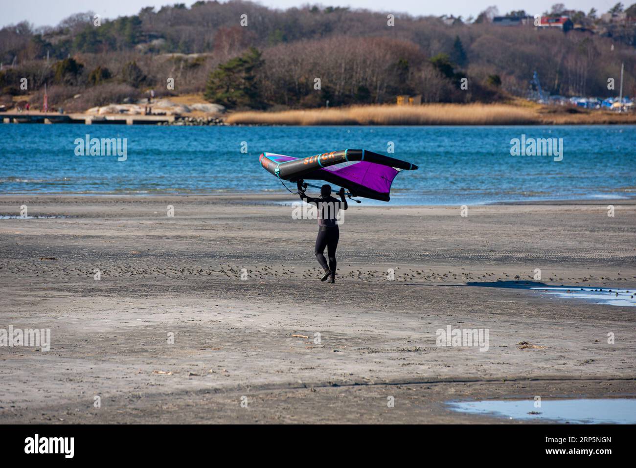 Göteborg, Schweden - 13. März 2022: Person, die an einem Strand spaziert und sich auf die Flügelfolie vorbereitet. Stockfoto