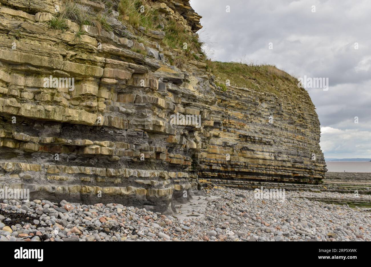 Diese Klippe an einem walisischen Strand zeigt, was die Auswirkungen der Küstenerosion und des Wetters im Laufe der Zeit auf die Felsschichten, die ihn stützen, bewirken können. Stockfoto