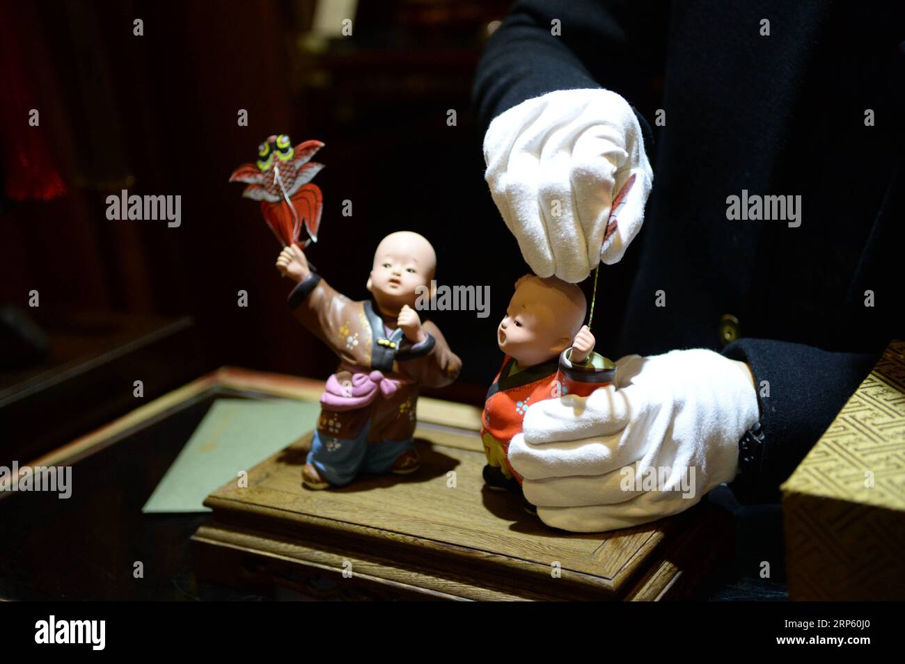 (181229) -- PEKING, 29. Dezember 2018 (Xinhua) -- Ein Mitarbeiter zeigt die Figuren in der Clay Figure Zhang Art Gallery in Tianjin, Nordchina, 28. Dezember 2018. Clay Figure Zhang ist ein bekannter Name für traditionelle Volkskunst in China, und solche Kunstwerke haben eine Geschichte von fast 200 Jahren. Zhang Yu, der sechste Generation von Tonfiguren in seiner Familie, übernahm das Familienunternehmen 1996, als er gerade einmal 18 Jahre alt war. Mit der Zeit haben sich Handwerk und Marke weiterentwickelt. Anstatt Figuren zu machen und sie wie ein Straßenverkäufer zu verkaufen, hat er Kunstmanager angeheuert, um die künstlerische va auszubeuten und zu vermarkten Stockfoto