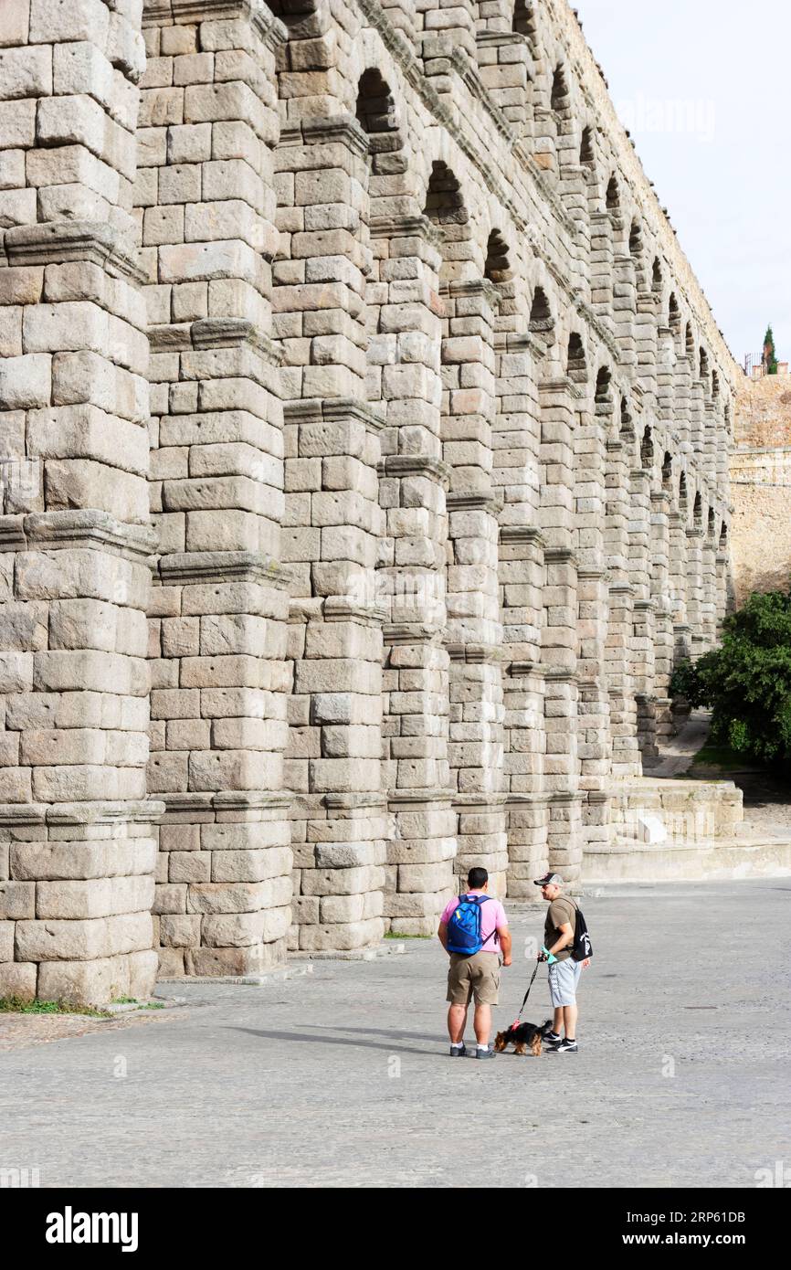 Blick auf Segovias römisches Aquädukt, mit winzigen menschlichen Figuren im Verhältnis Stockfoto