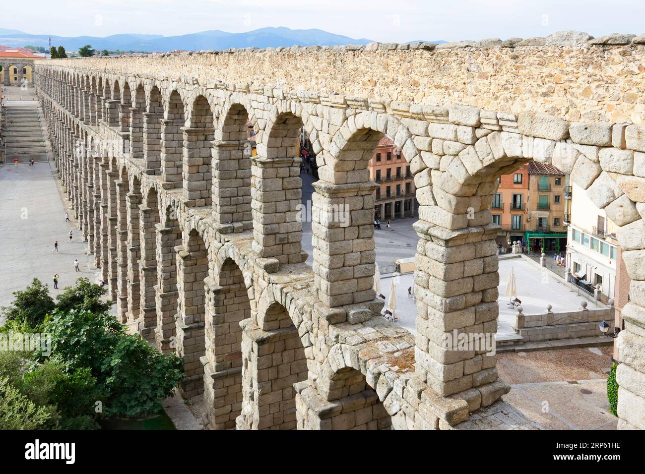 Winzige Menschen mit dramatischem Blick auf Segovias römisches Aquädukt Stockfoto