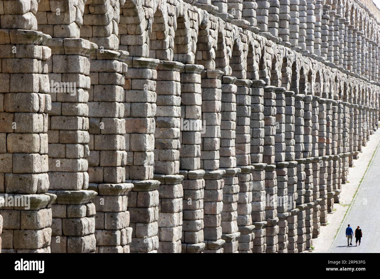 Blick auf Segovias römisches Aquädukt, mit winzigen menschlichen Figuren im Verhältnis Stockfoto
