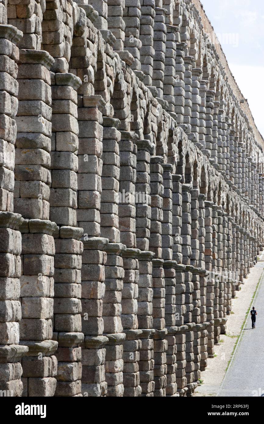 Blick auf Segovias römisches Aquädukt, mit winzigen menschlichen Figuren im Verhältnis Stockfoto