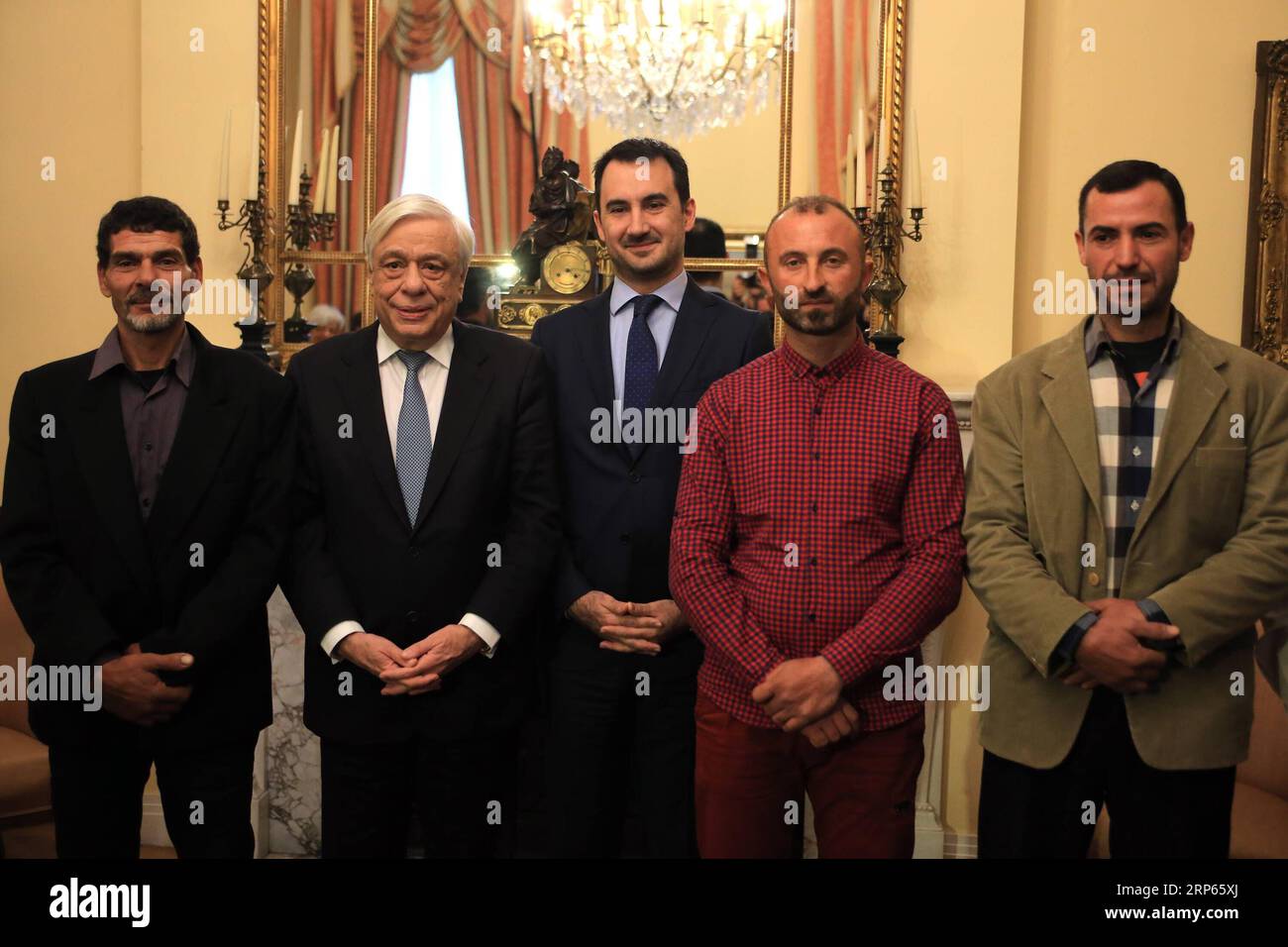 (190103) -- ATHEN, 3. Januar 2019 -- der griechische Präsident Prokopis Pavlopoulos (2., links) und Alexis Charitsis (3., links), griechischer Innenminister, posieren für ein Gruppenfoto mit den drei Fischern in der Präsidentenvilla in Athen, Griechenland, 2. Januar 2019. Die Ägypter Emand El Khamisi (50), Mahmoud Moussa (46) und der Albaner Jeka Gani (35) riskierten am 23. Juli 2018 neben vielen anderen einheimischen Fischern ihr Leben und retteten Dutzende von Menschen, die vor der Flamme flohen, die durch den Badeort Mati, etwa 30 Kilometer nordöstlich von Athen, fegte. Hundert Menschen starben an diesem Abend in den Flammen oder im Meer Stockfoto