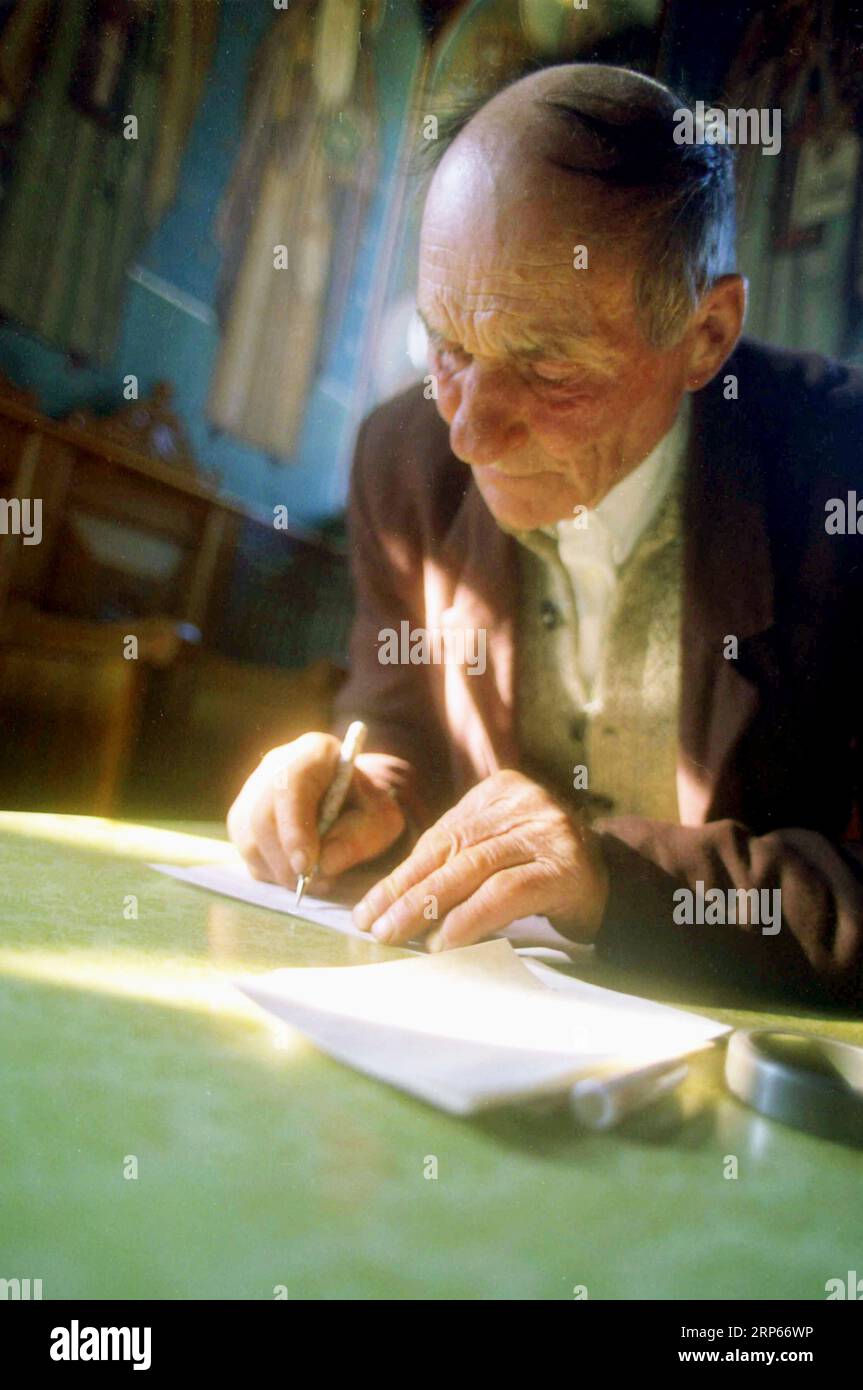 Bezirk Neamt, Rumänien, 1999. Ein Mann in einer Kirche, der ein "Pomelnic" schreibt, eine Liste von Leuten, für die er den Priester bitten würde zu beten. Stockfoto