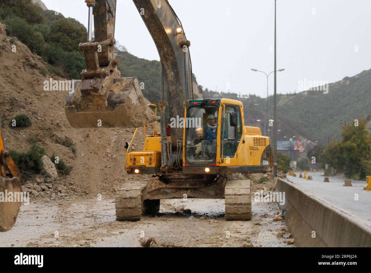 (190114) -- BEIRUT, 14. Januar 2019 -- Ein Arbeiter fährt einen Bagger, um eine Straße zu räumen, die durch einen Erdrutsch auf der Autobahn von der nördlichen Stadt Batroun nach Tschekka im Libanon, 14. Januar 2019, geschnitten wurde. Der Erdrutsch wurde durch Starkregen über Nacht verursacht. ) LIBANON-BATROUN-ERDRUTSCH Khalid PUBLICATIONxNOTxINxCHN Stockfoto