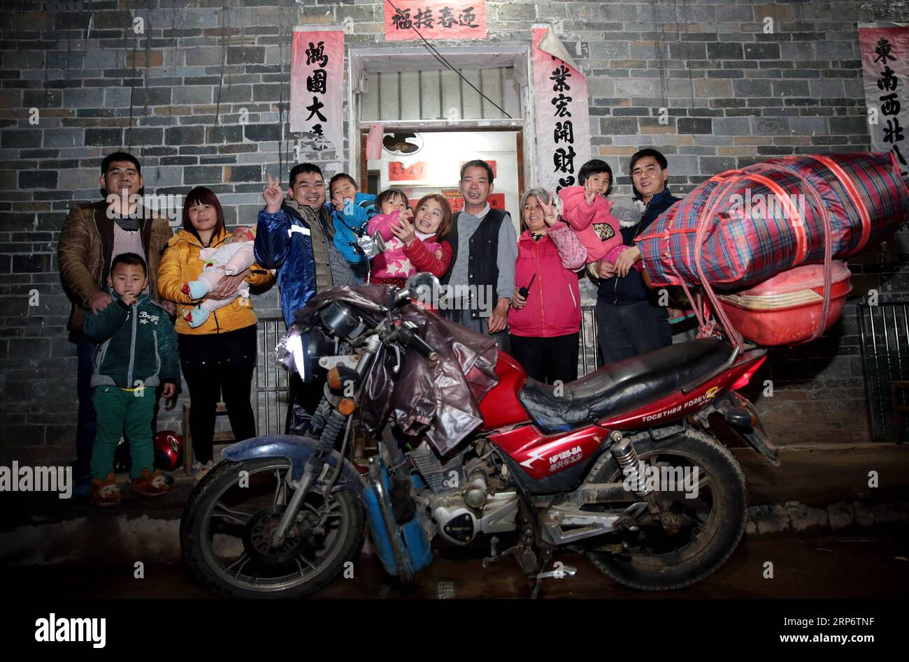 (190120) -- PEKING, 20. Januar 2019 (Xinhua) -- der Wanderarbeiter Chen Yifeng (8., R) und seine Frau Xu Lining (5., R) posieren für Fotos mit ihrer Familie nach einer 14-stündigen Motorradfahrt von Foshan, südchinesische Provinz Guangdong, zum Dorf Pingding, Teng County, südchinesische Autonome Region Guangxi Zhuang, 19. Januar 2017. Die Rückkehr in die Heimat ist nach wie vor der wichtigste Teil des Chinesischen Frühlingsfestes. Ob selbstfahrend, mit dem Zug oder mit dem Flugzeug, Homecomings und Familientreffen sind für viele Chinesen eine Priorität. Der jährliche Reisetag rund um das Festival, bekannt als chuny Stockfoto