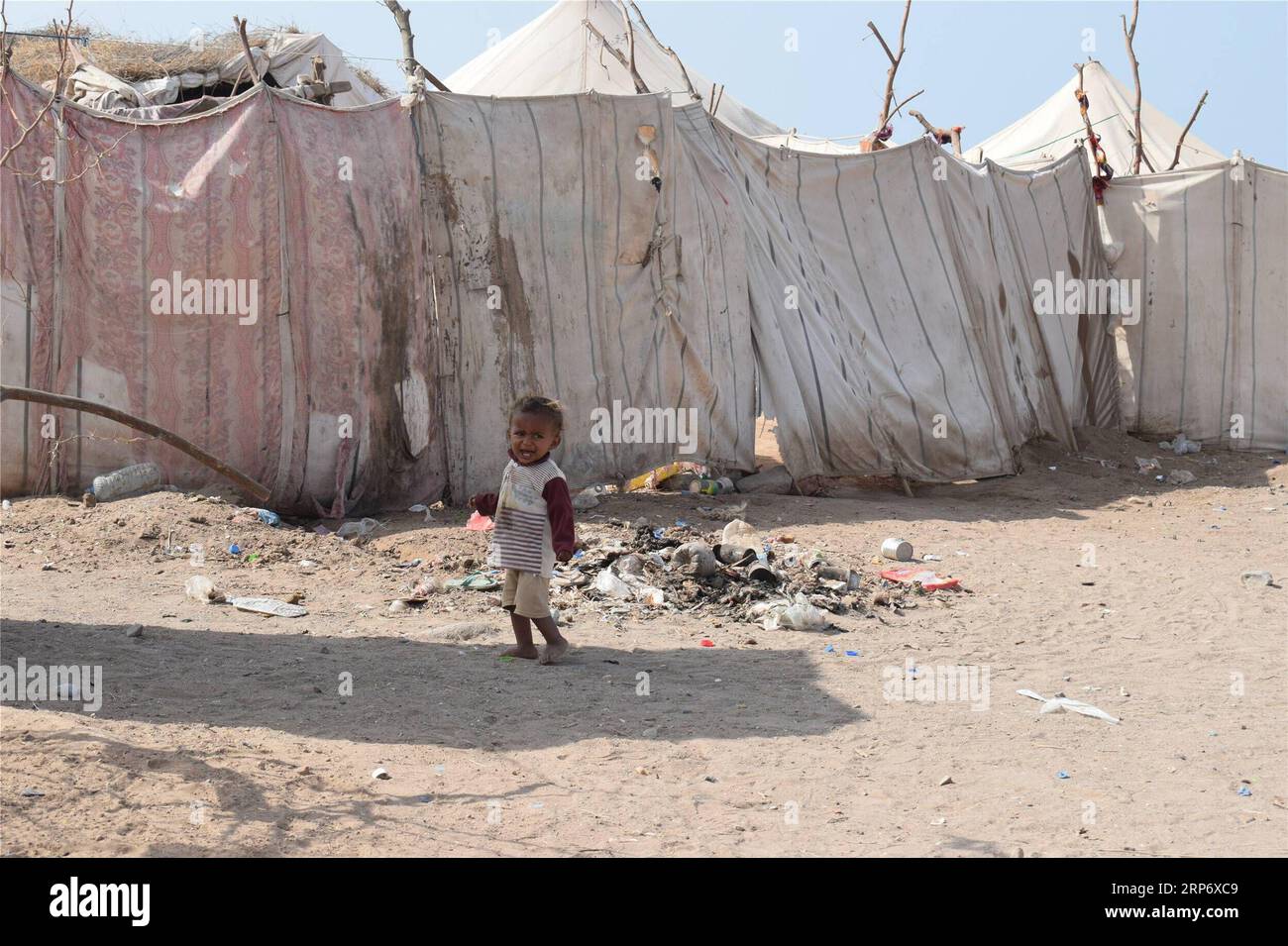 (190121) -- HODEIDAH (JEMEN), 21. Januar 2019 () -- Ein Kind geht am 21. Januar 2019 in der Nähe seines Zeltes in einem Vertreibungslager in Hodeidah, Jemen. Die beiden kriegführenden Seiten des Jemen hatten im vergangenen Monat unter der Schirmherrschaft der Vereinten Nationen eine Waffenstillstandsvereinbarung getroffen, doch konnte das Leid der Binnenvertriebenen in der Hafenstadt Hodeidah am Roten Meer nicht verringert werden. () JEMEN-HODEIDAH-BINNENVERTRIEBENE Xinhua PUBLICATIONxNOTxINxCHN Stockfoto