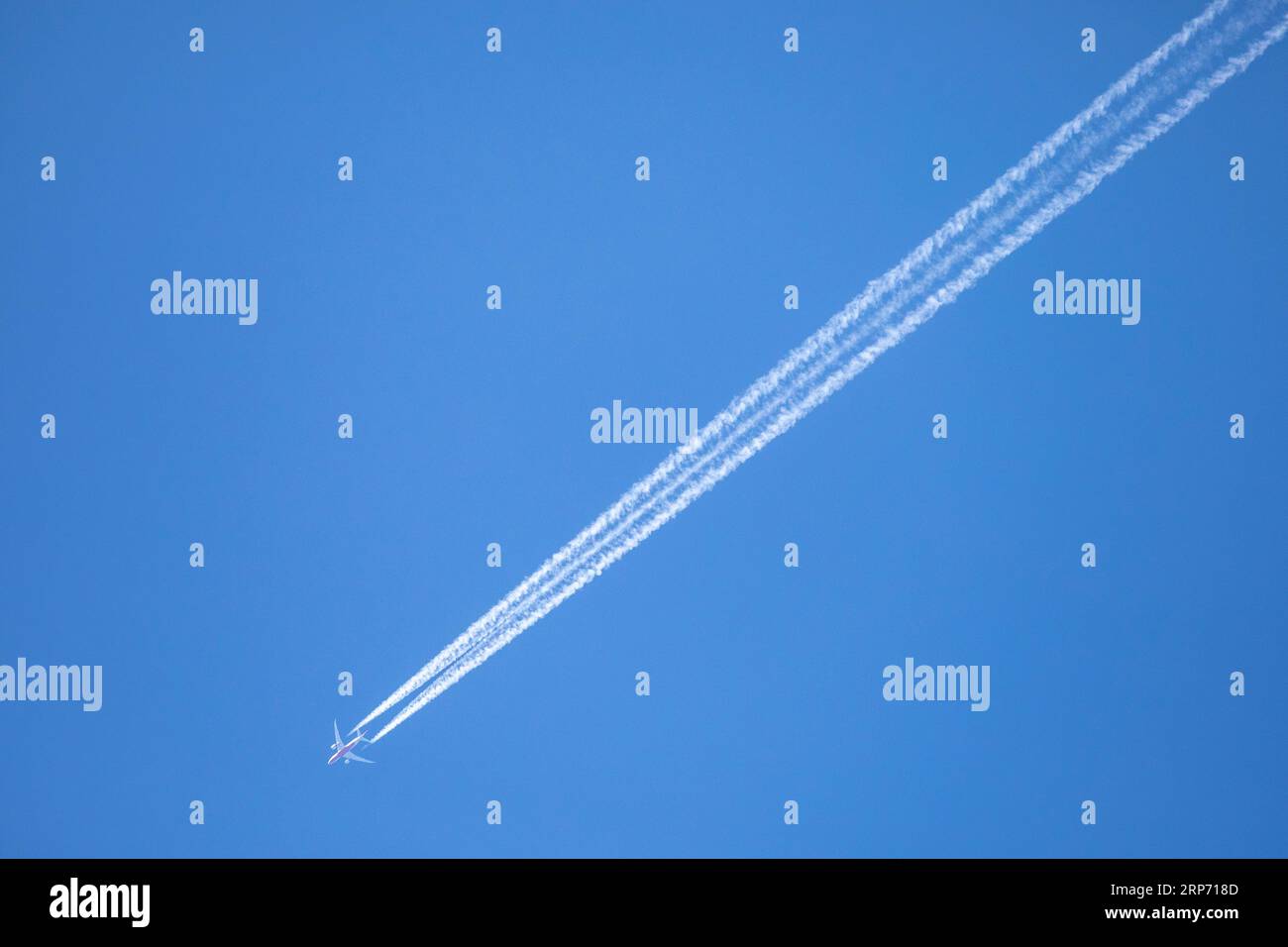 Ein Passagierflugzeug mit Kondensstreifen oder Dampflok gegen den klaren blauen Himmel in Bangladesch. Stockfoto