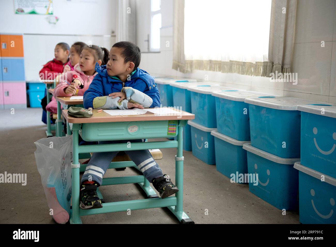 (190201) - Peking, Februar 1, 2019 (Xinhua) - Foto aufgenommen am 31.01.10, 2019 zeigt Shan Ziyuan (vorne) während einer Klasse in Taipingzhuang zentrale Grundschule, im Landkreis Yanqing von Peking, der Hauptstadt von China sieht. Der Helm und protectives Pads für Skating sind im blauen Kunststoffhüllen in ihrer Klasse Zimmer gestellt. Taipingzhuang zentrale Grundschule direkt am Fuße des Xiaohaituo Bergen, wo die Veranstaltungsorte für Beijing 2022 Olympischen Winterspiele im Bau befinden. Die Lehrer der Taipingzhuang zentrale Grundschule haben eine experimentelle Ackerland in eine saisonale Eisbahn gedreht Stockfoto
