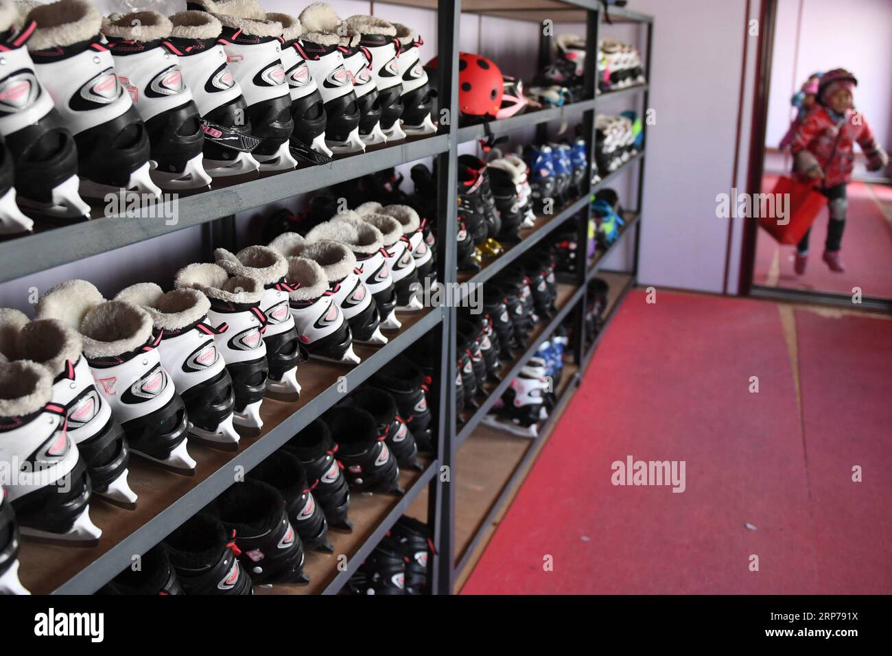 (190201) - Peking, Februar 1, 2019 (Xinhua) - Foto auf Jan. 10, 2019 zeigt ein Student in der Umkleide, wo die Schlittschuhe auf den Regalen bei Taipingzhuang zentrale Grundschule gespeichert werden, im Landkreis Yanqing von Peking, der Hauptstadt von China. Taipingzhuang zentrale Grundschule direkt am Fuße des Xiaohaituo Bergen, wo die Veranstaltungsorte für Beijing 2022 Olympischen Winterspiele im Bau befinden. Die Lehrer der Taipingzhuang zentrale Grundschule haben eine experimentelle Ackerland in eine saisonale Eisbahn für die Schüler hier lernen, Skaten seit 2016 gedreht. Die sch Stockfoto