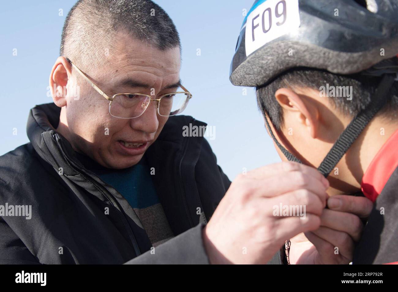 (190201) - Peking, Februar 1, 2019 (Xinhua) - Foto auf Jan. 23, 2019 zeigt, Leiterin Ding Jianpei (L) hilft einem Jungen, Zhang Heyan, mit seinen Helm in der Vorbereitung für eine Schulung bei Taipingzhuang zentrale Grundschule, im Landkreis Yanqing von Peking, der Hauptstadt von China. Taipingzhuang zentrale Grundschule direkt am Fuße des Xiaohaituo Bergen, wo die Veranstaltungsorte für Beijing 2022 Olympischen Winterspiele im Bau befinden. Die Lehrer der Taipingzhuang zentrale Grundschule haben eine experimentelle Ackerland in eine saisonale Eisbahn für die Schüler hier gedreht skatin zu erfahren Stockfoto