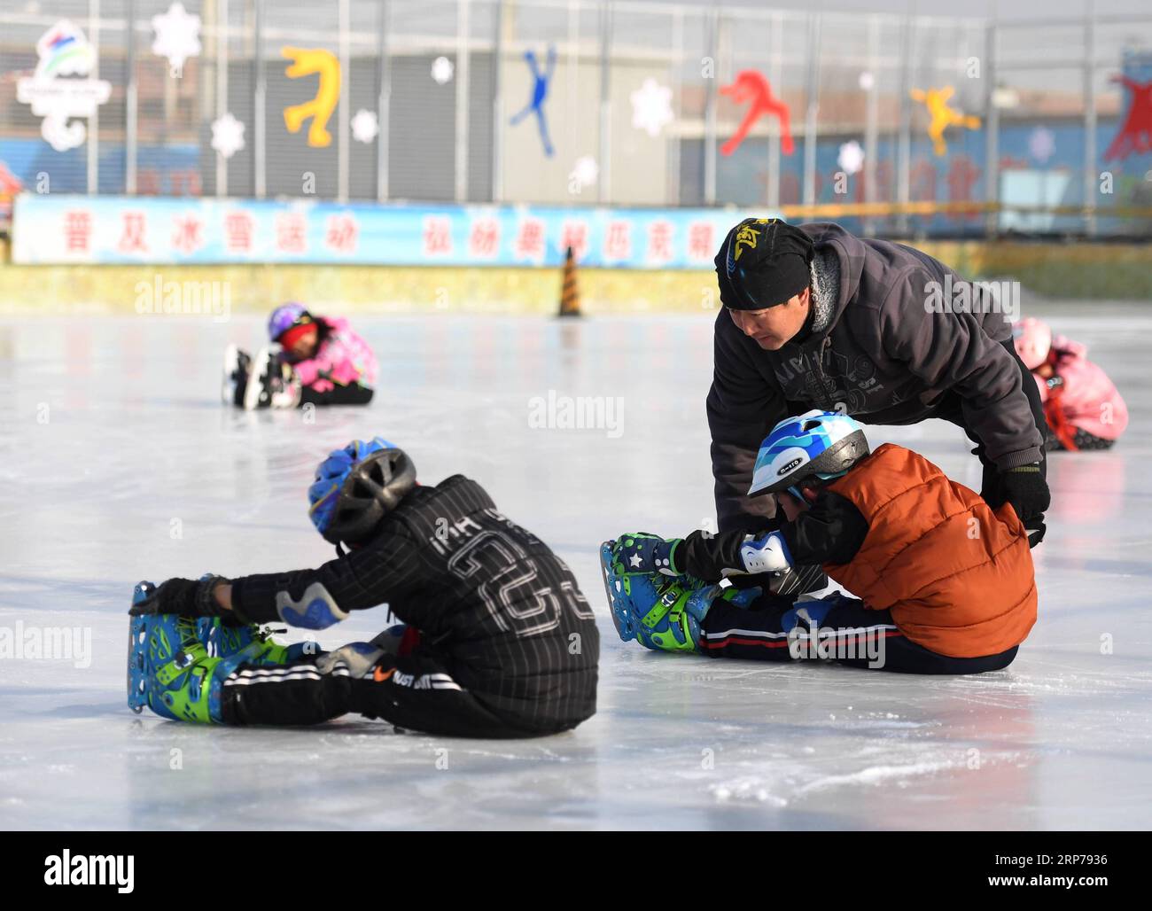 (190201) - Peking, Februar 1, 2019 (Xinhua) - Foto auf Jan. 9, 2019 zeigt Trainer Li Chunyu (R, oben) und seine Studenten während einer Schulung bei Taipingzhuang zentrale Grundschule im Landkreis Yanqing von Peking, der Hauptstadt von China. Taipingzhuang zentrale Grundschule direkt am Fuße des Xiaohaituo Bergen, wo die Veranstaltungsorte für Beijing 2022 Olympischen Winterspiele im Bau befinden. Die Lehrer der Taipingzhuang zentrale Grundschule haben eine experimentelle Ackerland in eine saisonale Eisbahn für die Schüler hier lernen, Skaten seit 2016 gedreht. Die Schule stellte eine Erfahrung Stockfoto