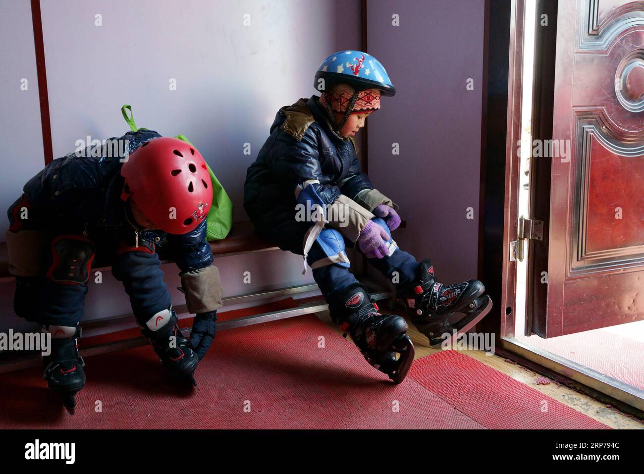 (190201) - Peking, Februar 1, 2019 (Xinhua) - Foto aufgenommen am 31.01.10, 2019 zeigt Cao Ming (R) auf seine Schlittschuhe in der Umkleide in Vorbereitung für eine Trainingseinheit setzt sich an Taipingzhuang zentrale Grundschule, im Landkreis Yanqing von Peking, der Hauptstadt von China. Taipingzhuang zentrale Grundschule direkt am Fuße des Xiaohaituo Bergen, wo die Veranstaltungsorte für Beijing 2022 Olympischen Winterspiele im Bau befinden. Die Lehrer der Taipingzhuang zentrale Grundschule haben eine experimentelle Ackerland in eine saisonale Eisbahn für die Schüler hier lernen, Skaten seit 2016 gedreht. Stockfoto