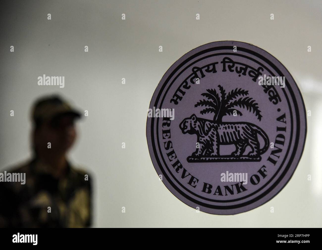 (190207) -- MUMBAI, 7. Februar 2019 (Xinhua) -- Ein Sicherheitspersonal steht in der Nähe des Logos der Reserve Bank of India (RBI) in seinem Hauptquartier in Mumbai, Indien, 7. Februar 2019. Indiens Zentralbank - die Reserve Bank of India (RBI) senkte am Donnerstag den Repo-Satz oder den Zinssatz, zu dem sie Geld an Banken leiht, um marginal 25 Basispunkte. Der neue Repo-Satz liegt jetzt bei 6,25 Prozent gegenüber den früheren 6,50 Prozent. (Xinhua/Stringer) INDIEN-MUMBAI-RBI GOUVERNEURSKONFERENZ PUBLICATIONxNOTxINxCHN Stockfoto