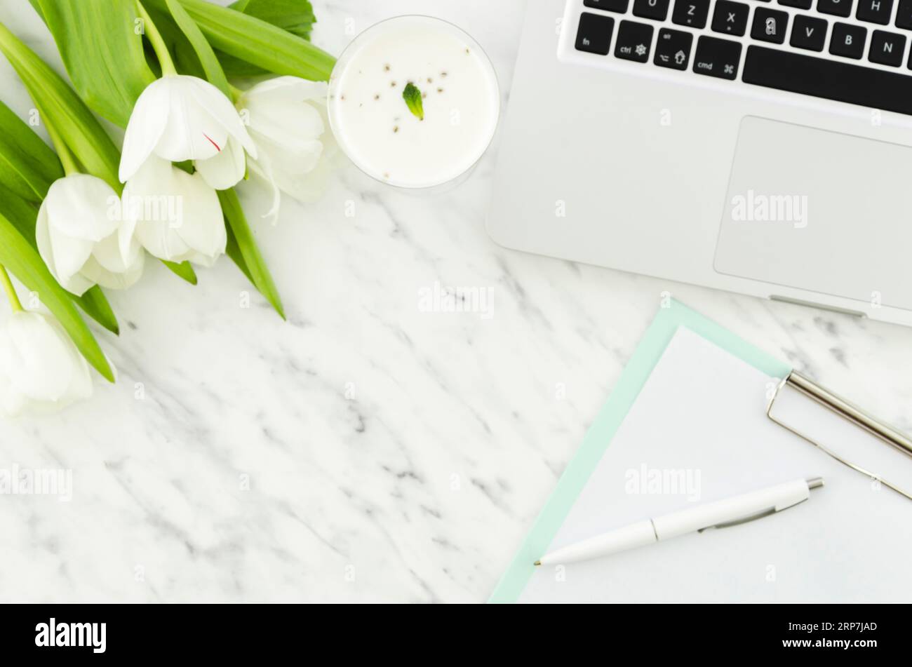 Laptop mit Tulpen-Tisch mit Klemmbrett Stockfoto