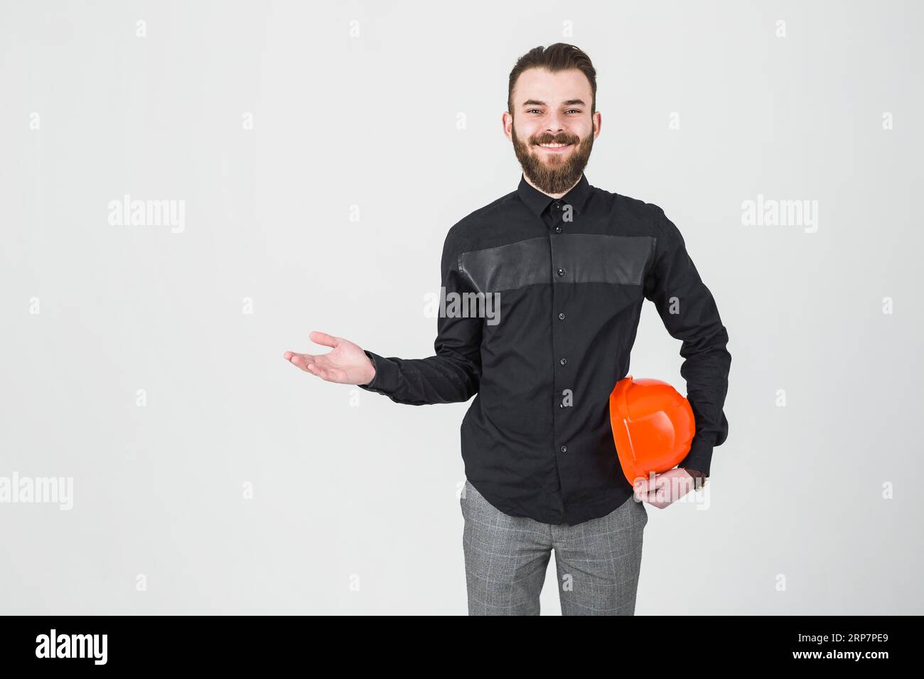 Ein lächelnder Ingenieur, der einen Hurt mit den Schultern hält Stockfoto