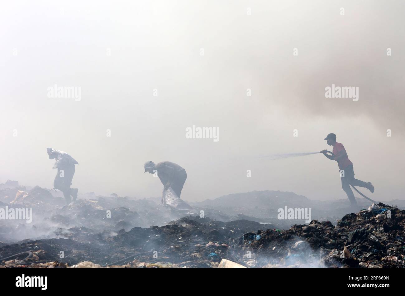 Gaza, Palästina. September 2023. Ein palästinensischer Gemeindearbeiter löscht ein Feuer in einer Mülldeponie in Juhr al-Deek, südöstlich von Gaza-Stadt. Die größte Mülldeponie fing aufgrund hoher Temperaturen und hoher Windgeschwindigkeiten Feuer an, und palästinensische Feuerwehrfahrzeuge stürzten aus, damit sie sich nicht auf Wohnviertel ausbreiteten. (Foto: Ahmed Zakot/SOPA Images/SIPA USA) Credit: SIPA USA/Alamy Live News Stockfoto