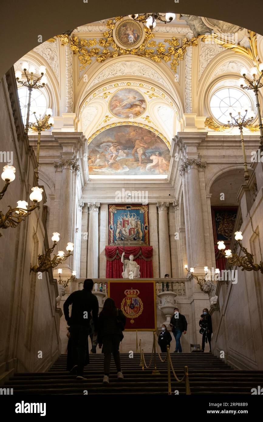 Große Treppe des Königspalastes von Madrid im März 2021 mit Besuchern, die wegen der COVID-19-Pandemie Masken tragen. Stockfoto