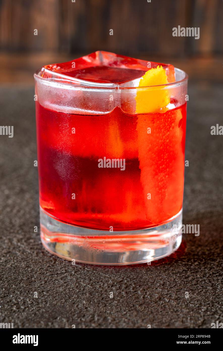 Ein Glas Negroni-Cocktail, garniert mit Orangenschale Stockfoto